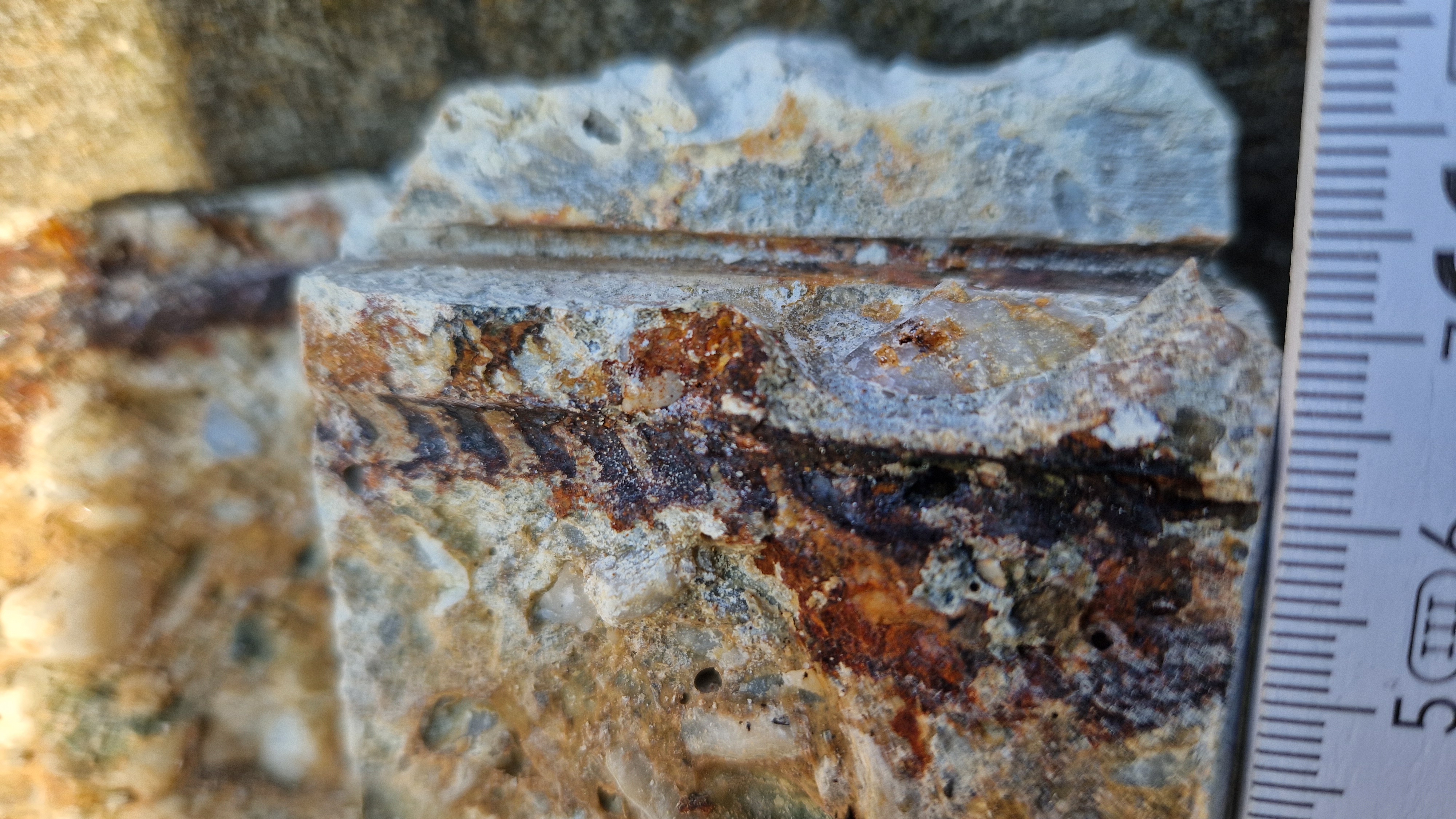 Bohrkerndetail mit Korrosionsspur an einem einbetonierten Stahlprofil