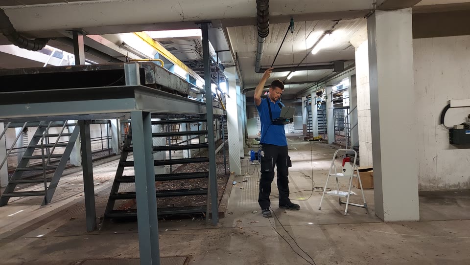 Fachkraft bei der Bauwerksaufnahme in einem Bestandsgebäude